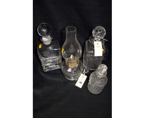 A 19th Century moulded glass table oil lamp with loop handle and glass chimney; together with a modern engraved glass decante