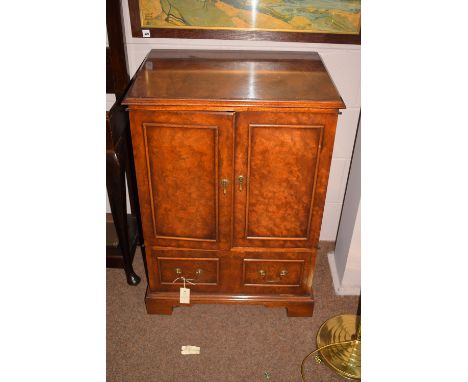 A walnut TV cabinet with two doors and pull down front, raised on bracket feet.