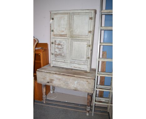 An early 20th Century painted kitchen cupboard with four panel doors; together with a distressed rectangular table with singl