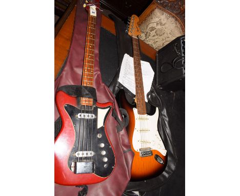 A vintage electric guitar with Burns Tri- sonic pickups and carrying case; a Squier Strat six-string electric guitar, with ca