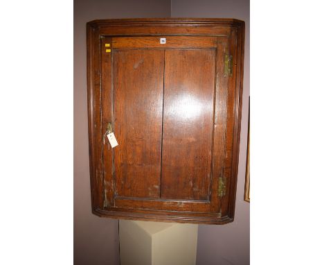 A 19th Century oak wall hanging corner cupboard, fitted a single panel door with brass butterfly hinges.