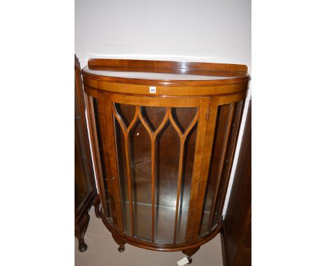 An early 20th Century walnut bow-fronted, tall, narrow display cabinet.