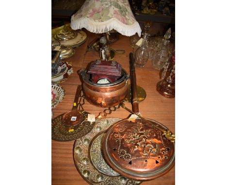 Copperware, to include; bed warming pan; strainer; pot; two brass strainers; a modern mantle clock; a table lamp in the form 