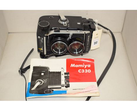 A Mamiya C330 twin lens professional camera with instruction book.