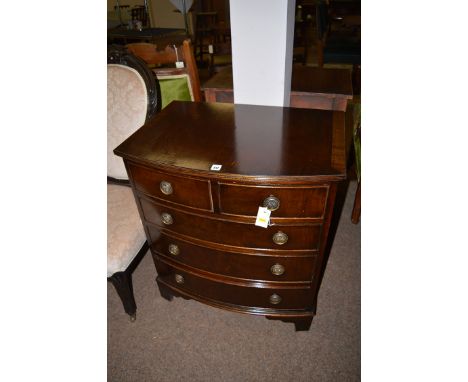 A reproduction mahogany bowfront chest of drawers, two short and three long drawers, raised on bracket feet, 27in. wide.
