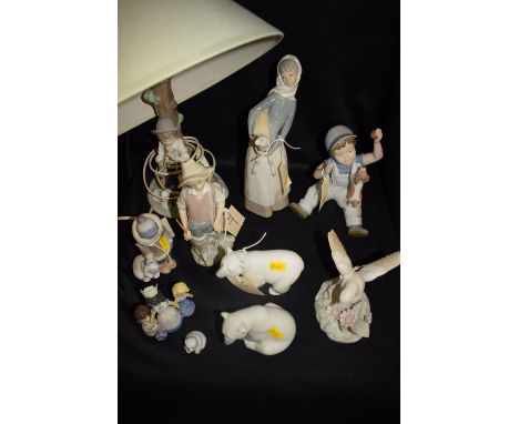 A Nao ceramic table lamp modelled as a shepherd boy; together with three Lladro figures: a boy, a girl and an Eskimo child; t