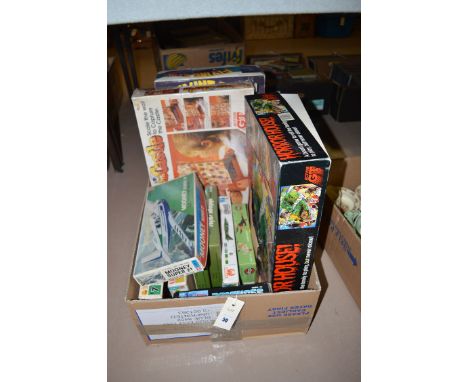 A box of children's toys, to include; jigsaws; a Horror House board game; a boxed flying stunt loco; and model aircraft kits.