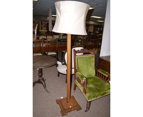 A 20th Century oak standard lamp and shade.