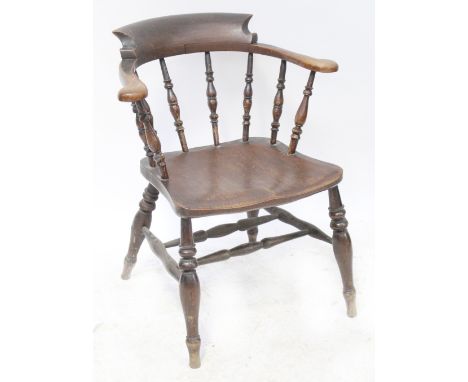 A 19th century provincial captain-style Windsor armchair with spindle supports, one-piece saddle seat united by double stretc