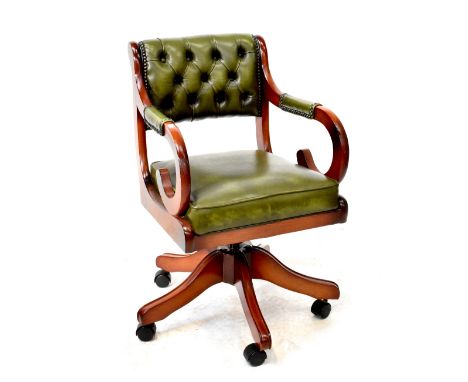 A reproduction button back swivel office chair in green leatherette, on a five-prong base with castors.