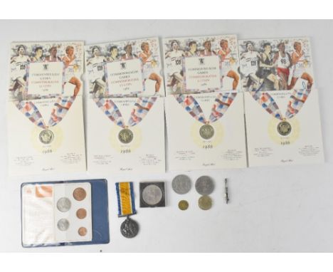 Three Royal Mint cased Commonwealth Games commemorative £2 coin sets, a small white metal Edwardian brooch in the form of a p