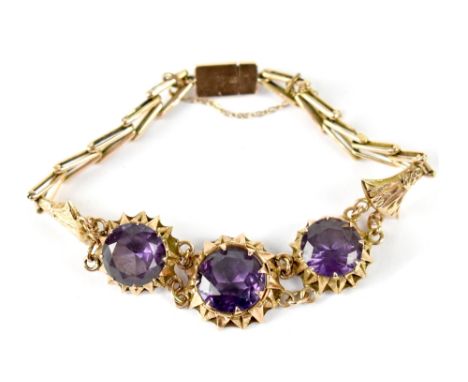 A foreign gold bracelet, possibly Egyptian, with three large claw set blue stones joined by chain and arrow links, with safet