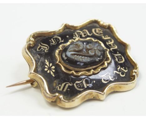 A Victorian memorial brooch, black enamel, gold colour lettering to the front with carved jet insert, back crystal missing.