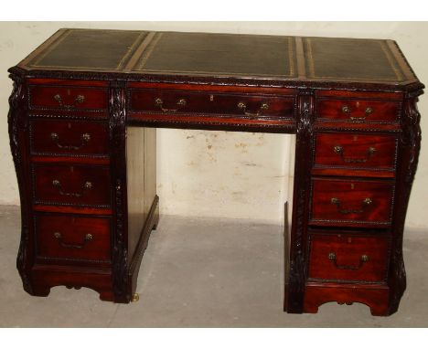 A late 19thC / early 20thC mahogany kneehole desk, in the manner of Thomas Chippendale, the rectangular top with three black 