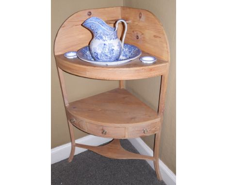 A 19thC stripped pine corner washstand, with a shaped back, recesses for beakers and bowls above an undertier with a central 