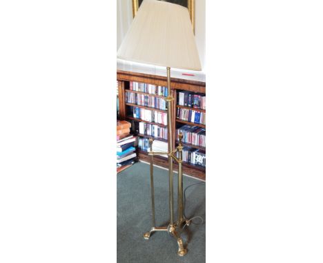 A 20thC brass floor lamp, in Art Nouveau style with cylindrical column, with square section supports on a triform base with r