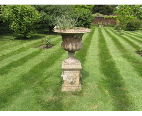 A terracotta campana garden urn, with Bacchanalian frieze, on a stoneware pedestal, 130cm high (AF).