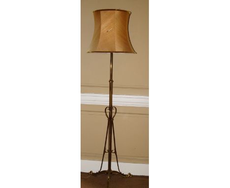 An Art Nouveau style brass adjustable floor lamp, of tubular form with shaped supports and feet, with a shade, 175cm high ove