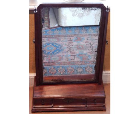 A late 18thC/early 19thC mahogany dressing table mirror, the rectangular plate on plain tapering end supports, the base with 