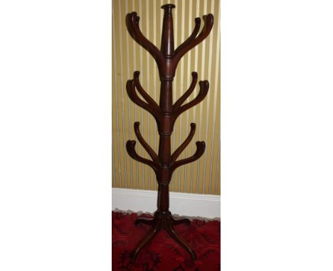 An early 19thC mahogany hat or coat stand, with central turned support and twelve shaped arms on tripod base, 166cm high