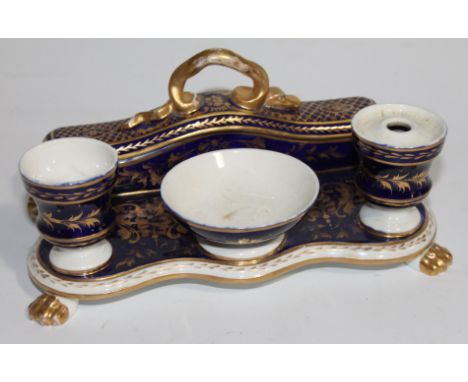 An early 19thC Crown Derby porcelain desk stand, of serpentine form with integral pen box and inkwell, gilt foliate decorated