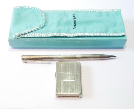 Zippo-style lighter in silver case for Tiffany &amp; Co., and a silver ballpoint pen, for the same.&nbsp; (2)