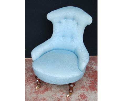 19th century mahogany lady's armchair, the shaped back rest upholstered in later blue button-back fabric, on ceramic castors,