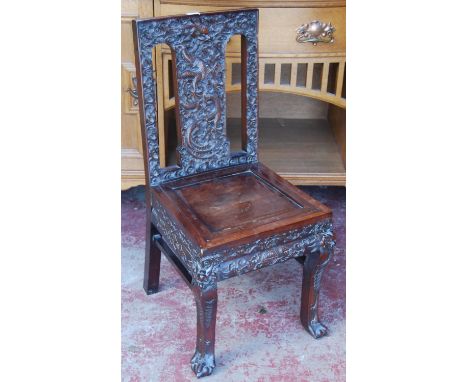 Chinese Qing carved hongmu chair carved profusely with dragons, flaming pearl and scrolls to the back rest and frieze, on bal