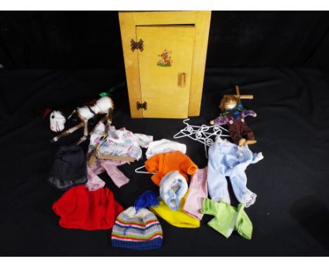 Dolls - A vintage unmarked dolls wooden wardrobe approx 41cms (H) x 22cms (W) x  16 cms (D), containing several dolls outfits