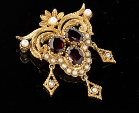 A 9ct gold, garnet and half pearl set drop pendant brooch, the oval garnet to the centre of the scroll work design with small
