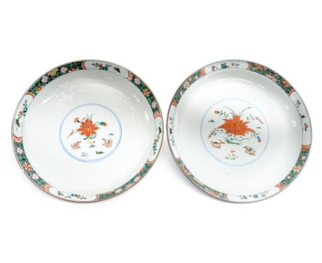 A near pair of Chinese export ware cafe au lait saucer dishes, Kangxi period, each with lotus radiating from a enamelle and l