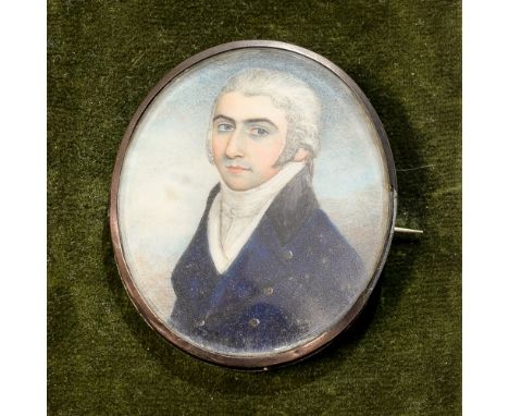 A George III oval portrait miniature, bust of a young gentleman wearing a green button tunic, lock of hair and monogram verso