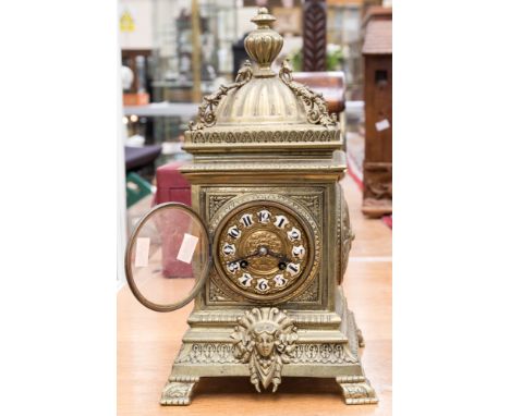 A late 19th Century French brass bracket clock, the case of Baroque design, finial and cupola, inset enamel Roman numerals to