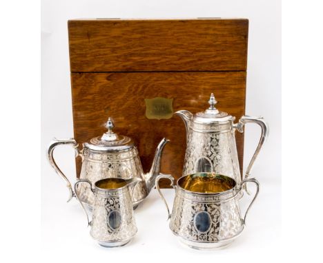 An oak box, material lined with a three piece tea service plus hot water pot, silver with original bags to cover items, the s