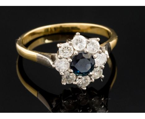 A sapphire and diamond 18ct yellow gold round cluster ring, the centre blue sapphire measuring approximately 5.11mm diameter 