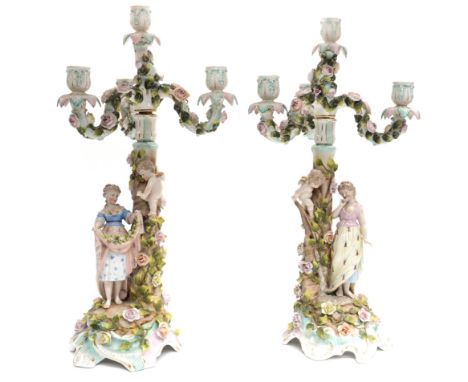 A late 19th Century German bisque porcelain figural candelabra garniture, including a pair of florally encrusted three branch