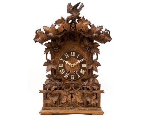 An early 20th Century Black Forest bracket cuckoo clock, modelled as a vine clad chalet with pitched roof, height 45cmConditi