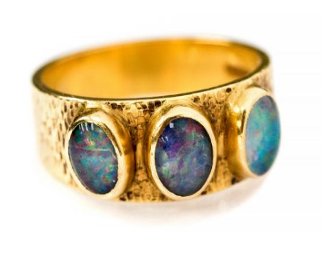 A black opal three stone 18ct gold band ring, hallmarked for 1971, the oval cabochon cut opal approximately 7mm by 5mm, ring 