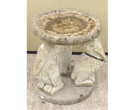 A reconstituted stone 'Pelican' bird bath in the form of a shaped round bowl on three pelican supports and a round base, H54c