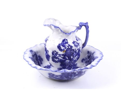 A Blakeney Ironstone pitcher and basin. Having a fluted rim and printed in a pattern of blue roses on a white ground, pitcher