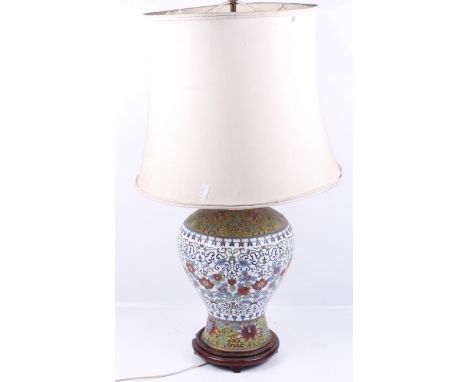 A large Chinese cloisonne table lamp. Of baluster form with height adjustable shade raised on a red hardwood base. Vase size 