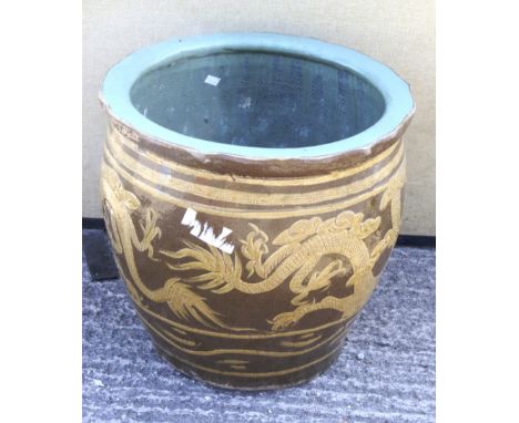 A large glazed garden pot decorated with a Chinese dragon. On a light brown ground, the interior glazed in turquoise, 48cm hi