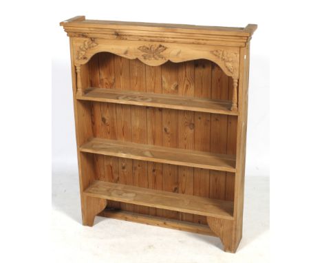 A pine freestanding bookcase, possibly repurposed from a kitchen dresser. Having a stepped cornice and three shelves, the upp