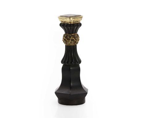 An antique ebony desk seal, the ebony handle with a tapering hexagonal section and a flared pommel, to chased floral gold mou