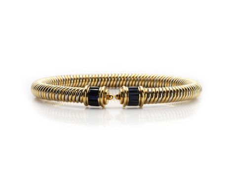 An 18ct gold sapphire bangle, the bangle of twisted design, with white and gold alternating twists, each set with baguette cu