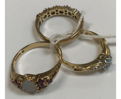 Three 9 carat gold dress rings, one set with opal, another with aquamarine and the other red and white stones, total weight a