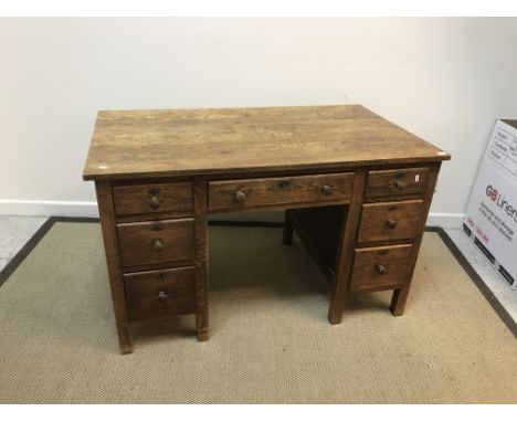 An early to mid 20th Century oak double pedestal desk with central slim drawer flanked by two banks of three drawers, 121.5 c