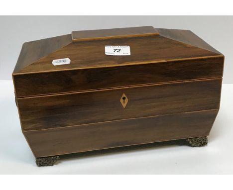 An early 19th Century rosewood veneered and satinwood strung tea caddy of sarcophagus form, the rising lid opening to reveal 
