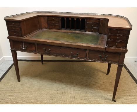 A mahogany Carlton House desk in the Regency style, the curved superstructure with various drawers, cupboards and pigeonholes