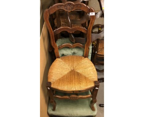 A set of six French oak carved ladder back dining chairs with rush seats, together with a modern oak framed ladder back rush 